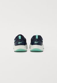 Baskets de sport bleu marine avec une tige en mesh texturé, des accents vert menthe et une semelle intermédiaire blanche mouchetée, présentant une boucle à l'arrière.