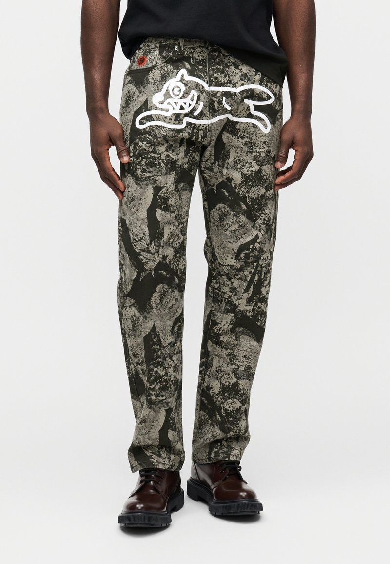 Παντελόνια με σχέδιο παραλλαγής σε αποχρώσεις του πράσινου και του γκρι, με ένα λευκό γραφικό ενός πηδώντας σκύλου στο πίσω μέρος και ανθεκτική μέση.