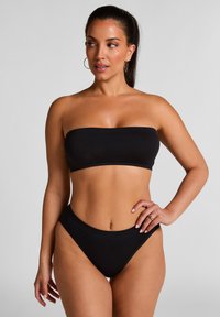 Zwarte bandeau bikinitop met een naadloos ontwerp, gecombineerd met high-waisted bikinitaille. Soepele textuur, minimalistische stijl zonder versieringen.