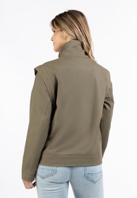 Khaki kurtka z wysokim kołnierzem, dopasowanym krojem i długimi rękawami. Gładki materiał z minimalnie widocznymi szwami i schludnym wykończeniem.