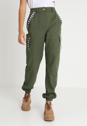 Pantalons cargo verts avec des poignets élastiques, dotés de poches latérales, d'accents en chevrons blancs et d'une coupe décontractée. Fabriqués en tissu léger.