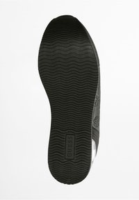 Suola di scarpa nera con motivo testurizzato e ondulato. Presenta un logo "GUESS" in evidenza su uno sfondo rettangolare. Bordi lisci e design resistente.