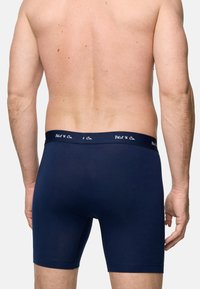 Mörkblå boxerkalsonger i mjukt tyg. Har en elastisk midja med "Phil & Co."-logotyp, slät textur och figurnära design.