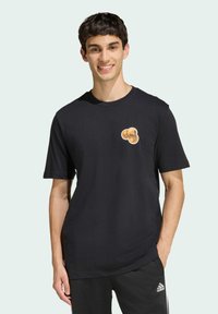 Černé bavlněné tričko s kulatým výstřihem, krátkými rukávy a potiskem se třemi zlatými mincemi na hrudi.