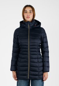 Giacca puffer blu scuro con cappuccio, caratterizzata da sezioni trapuntate verticali, una zip frontale e dettagli arancioni. Realizzata in un materiale liscio e leggero.