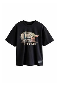 Musta puuvilla t-paita, jossa on graafinen printti hahmosta, jolla on suuret korvat ja kypärä, ja tekstillä japaniksi suunnittelun alla.