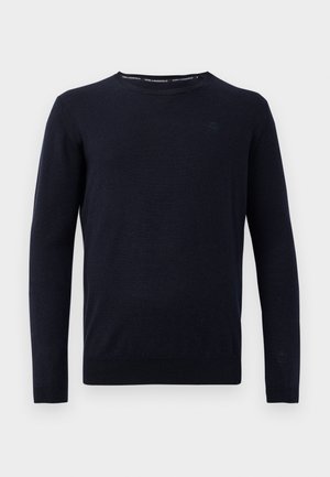 Marineblauwe gebreide trui met een ronde halslijn en lange mouwen. Kenmerkt zich door een subtiele logo op de borst en geribde manchetten en zoom.