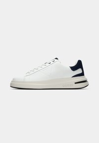 Sneakers de pele branca com acentos em azul escuro, bico arredondado, design de atacadores e sola espessa bege com uma faixa preta. "GUESS" embossado de lado.