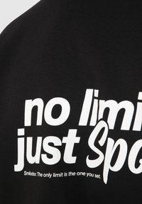 T-shirt noir avec un grand texte blanc : "pas de limite juste Spg" et un texte plus petit en dessous : "Smilodox : La seule limite est celle que vous fixez."