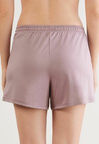 Lichtpaarse, zachte stofshorts met een elastische tailleband, met een ontspannen pasvorm en afgewerkte randen. Geen zichtbare patronen of hardware.