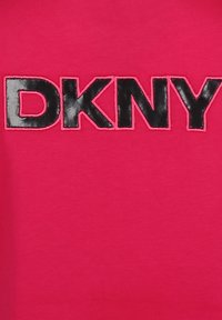 Tela rosa con un atrevido logo bordado en negro "DKNY" contorneado en hilo rosa, con una textura suave y un ligero brillo.