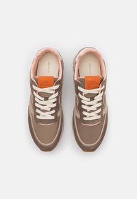 Bruine en roze sportschoenen met vetersluiting, gemaakt van suède en mesh materialen, oranje logotag, contrasterende stiksels en een rubberen zool.