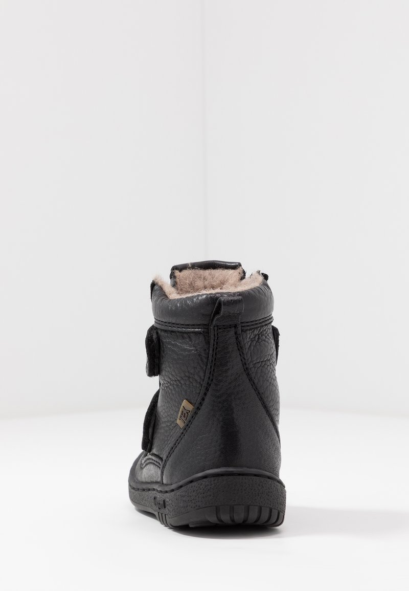 Czarne skórzane botki za kostkę z teksturowanym wykończeniem, wyposażone w miękką podszewkę z sztucznego futra, rzep oraz teksturowaną gumową podeszwę.