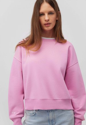 Rosa Fleece-Sweatshirt mit rundem Ausschnitt, überschnittenen Schultern, gerippten Bündchen und Saum. Mit einem kleinen Logo auf dem Ärmel.