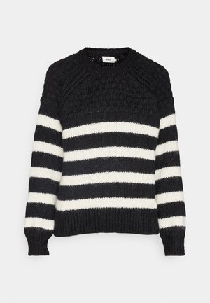 Crna i bijela prugasta džemper s teksturiranim, pletenim uzorkom. Ima okrugli izrez i rebraste manžete i rub.