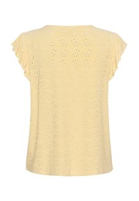 Haut jaune clair avec des manches froncées, présentant un motif texturé de petits trous. Tissu lisse avec une coupe décontractée.