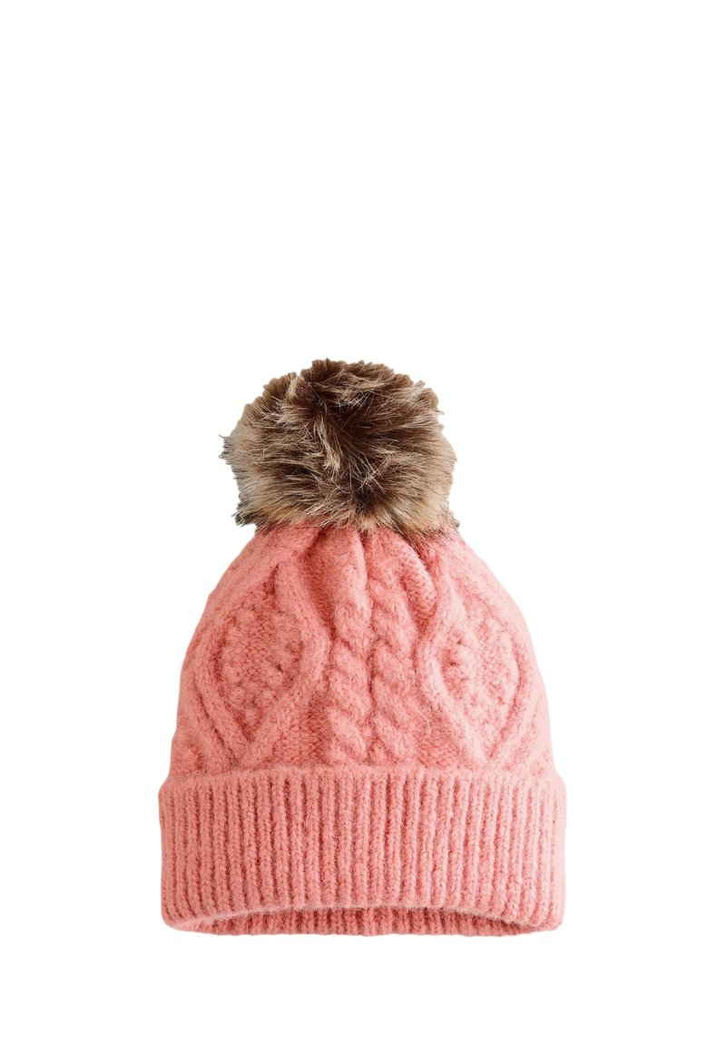 Cappello di lana rosa lavorato a maglia con motivo a treccia e grande pompon in pelliccia sintetica marrone sopra, isolato su sfondo bianco.