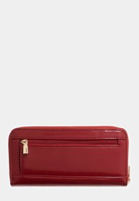 Portafoglio in vernice rossa con compartimento con zip, forma rettangolare piatta e dettagli in metallo dorato. Texture liscia e design elegante.