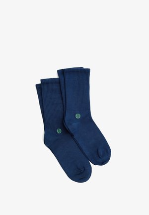 Marineblauwe katoenen sokken met een geribde textuur. Voorzien van een klein groen logo aan de zijkant. Ontworpen voor comfort en duurzaamheid.