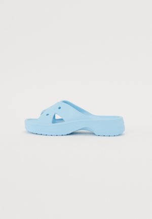 Lys blå slide sandal lavet af tekstureret gummi, med et tværgående stropdesign og ventilationshuller. Sålen har et mønstret greb.