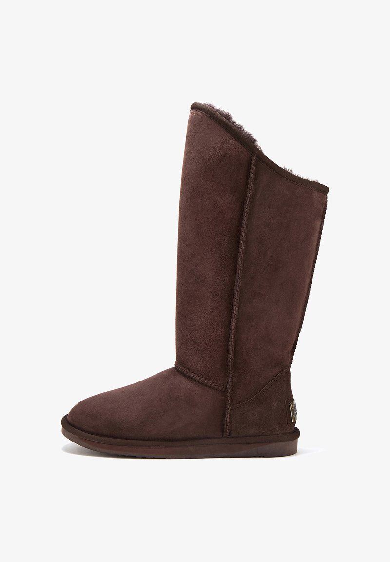 Hnědé semišové kozačky po kolena s kulatou špičkou, texturovaným povrchem, šitými švy a kožíškovým podšívkou na okraji. Plochá gumová podrážka.
