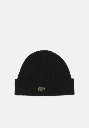 Black ribbed knit beanie with a folded cuff and a small green and red Lacoste logo on the front. Soft texture, close-fitting design.