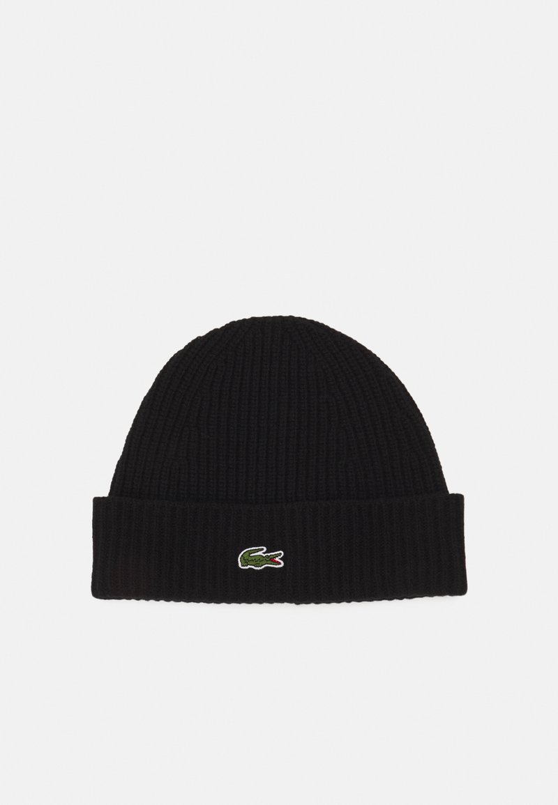 Svart ribbestrikket beanie med brettet mansjett og en liten grønn og rød Lacoste-logo på forsiden. Myk tekstur, tettsittende design.