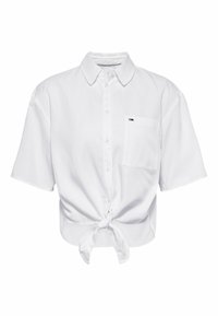 Camicia bianca a maniche corte in cotone. Presenta un colletto button-down, una tasca frontale e un orlo annodato in vita.