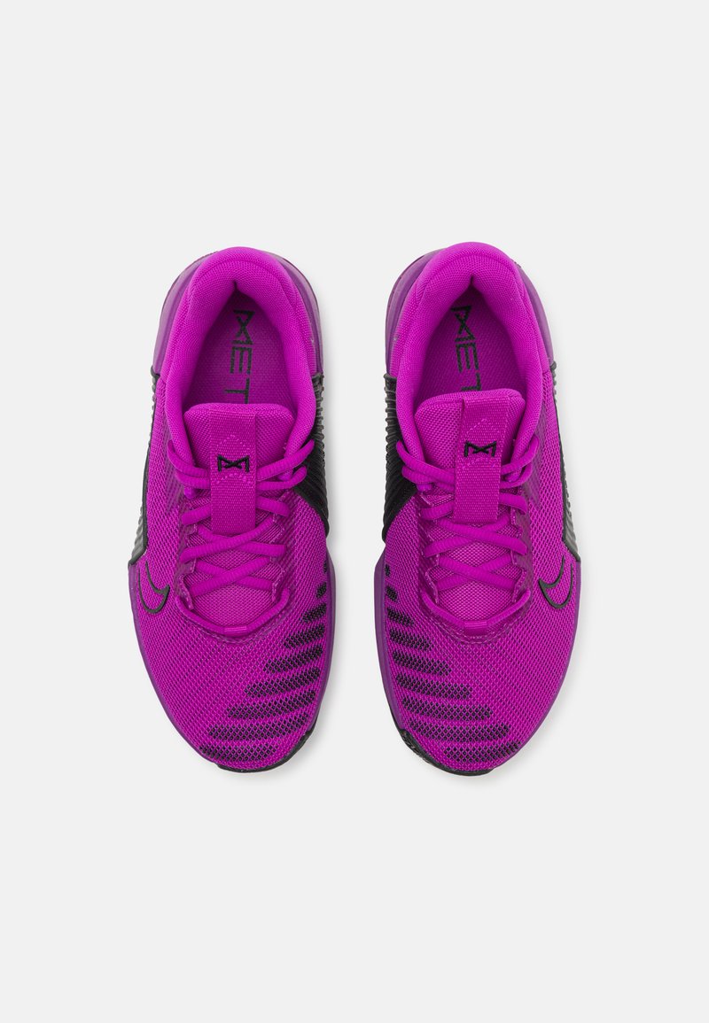 Zapatillas deportivas moradas con parte superior de malla y acentos en negro. Las características incluyen cordones, una marca prominente y un diseño de suela texturizada.