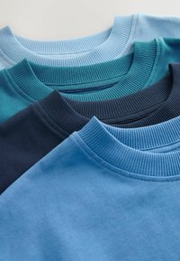 Négy crewneck pulóver egymásra rakva, különböző kék, türkiz és mélykék árnyalatokban. Mindegyik ribbelt gallérral és sima szövettextúrával rendelkezik.