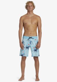 Pantaloni da bagno blu con un motivo di palme e sole, dotati di vita regolabile con cordino, lunghezza al ginocchio e una texture leggera.