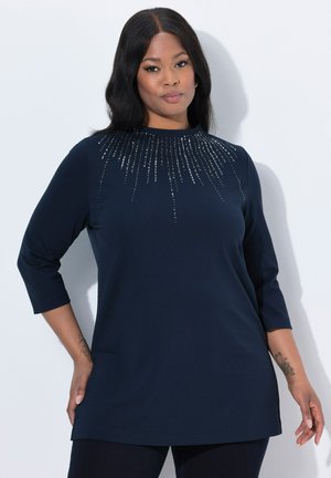 Donkerblauw longsleeve shirt met een ronde hals, versierd met cascades van rhinestones op de borst en heeft een relaxte pasvorm. Zachte stof met een gladde textuur.