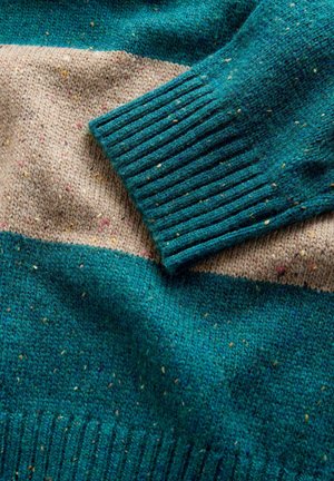 Maglione lavorato a maglia testurizzato con un corpo turchese e una striscia beige. Macchie multicolori aggiungono dettagli al tessuto. Polsini a coste inclusi.