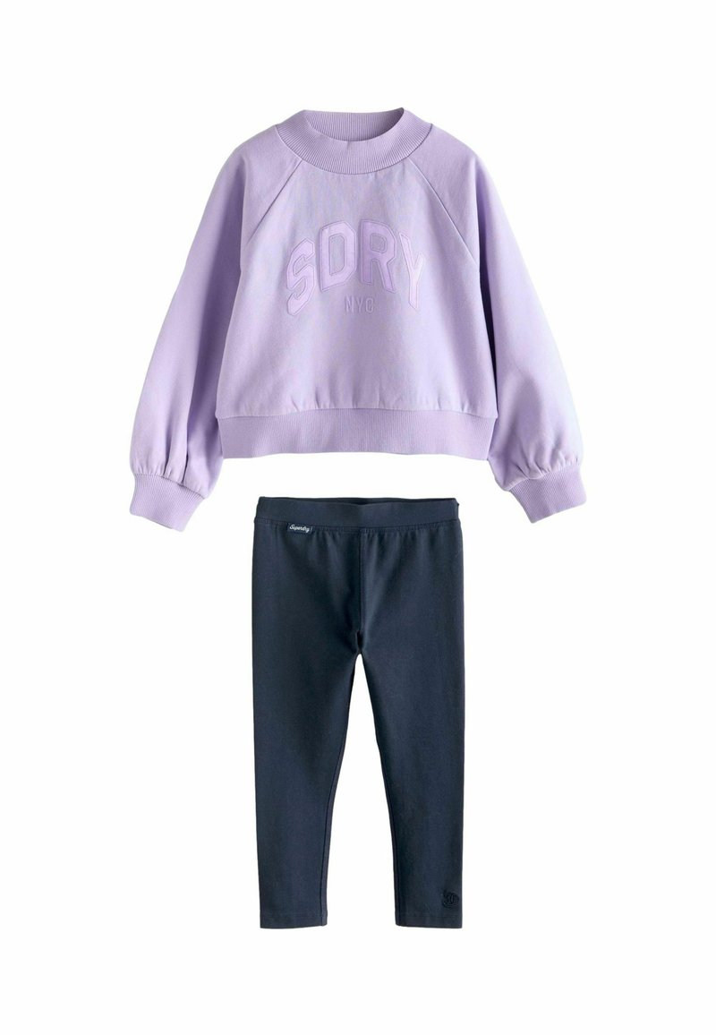 Fialová mikina s vyrazeným textom "SDRY NYC", v kombinácii s čiernymi legínami. Mikina má raglánové rukávy a ribovaného goliera.