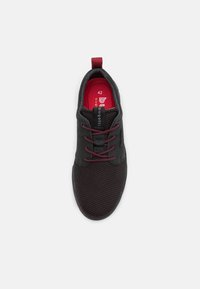 Černé tenisky s síťovaným svrškem, vínovými tkaničkami a límcem. Obsahují červenou stélku se štítkem velikosti 42, doplněnou o značkovou etiketu na boku.