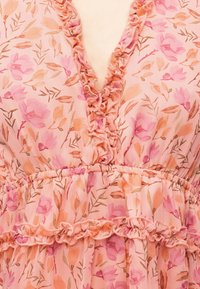 Rochie florală roz și piersică cu decolteu în V cu volane și detaliu cu talie adunată, confecționată dintr-un material ușor și texturat.