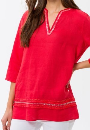 Haut en lin rouge avec un col en V, manches trois-quarts, et bordure décorative le long de l'encolure et de l'ourlet. Léger et de coupe décontractée.