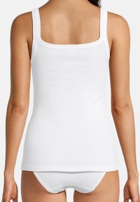 Top in cotone bianco a costine con scollatura quadrata e spalline larghe, abbinato a pantaloni short boyshorts in cotone bianco e a costine. Materiale morbido e elasticizzato.