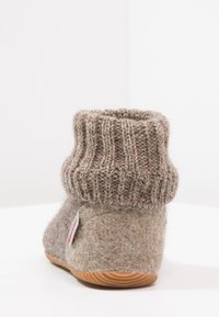 Grijze felt slippers met een geribbelde gebreide manchet, met een afgeronde vorm en een houten zool. Opvallend door de gemêleerde stof en het labeldetail.