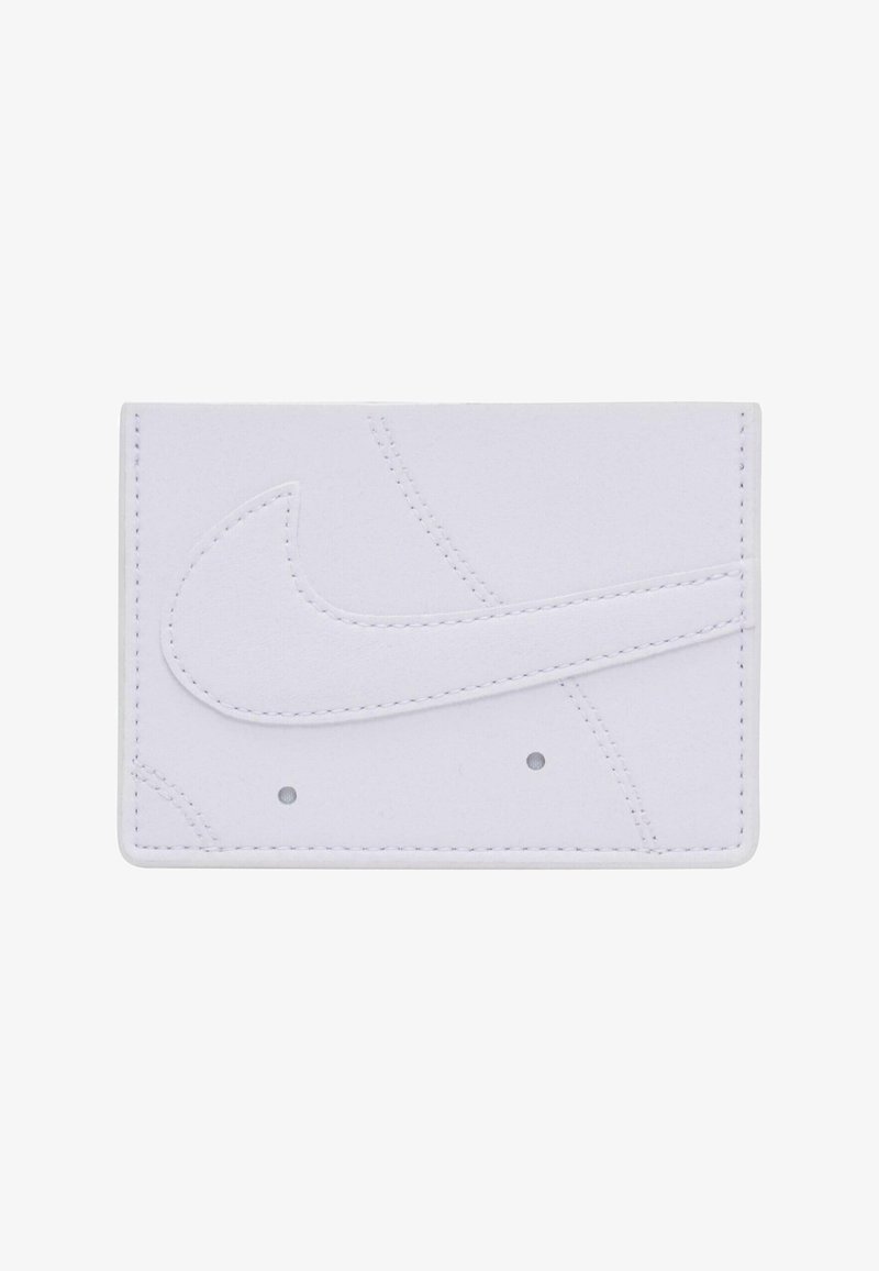 Biała skórzana portmonetka na karty z dużym wytłoczonym logo Nike swoosh, dekoracyjnym przeszyciem oraz dwoma małymi perforacjami u dołu.