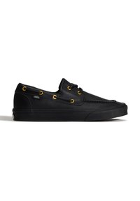 Černé nízké lodní boty Vans z kůže se zlatými průchody na tkaničky a černými tkaničkami, texturovaný svršek a silná gumová podrážka na bílém pozadí.