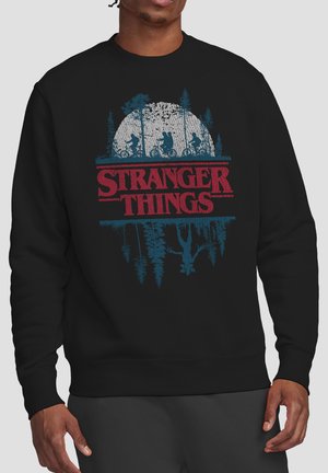 Black sweatshirt with red "Stranger Things" text, silhouettes of kids riding bikes in front of a moon, and an upside-down figure below.