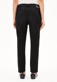 Svarta denimjeans med rak passform, utrustade med två bakfickor och en logotypetikett i midjan. Tyget har en slät struktur.