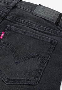 Μαύρο τζιν από denim με πίσω τσέπη σε σχήμα καρδιάς, αντίθετη ραφή και δερμάτινη ετικέτα με υφή της μάρκας στη μέση.