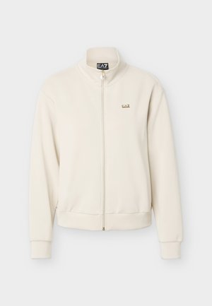 Veste beige à manches longues avec fermeture éclair, col montant, poignets côtelés et petit logo doré EA7 sur la poitrine gauche.