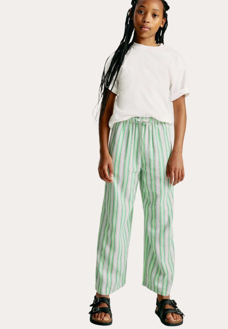 Groene en witte gestreepte linnen broek met een elastische tailleband, relaxte pasvorm en touwtje, gecombineerd met een plain wit T-shirt met korte mouwen.