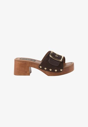 Sandalia de tacón de madera marrón con tira ancha marrón oscuro, hebilla dorada y tachuelas metálicas redondas a lo largo del lateral de la suela.