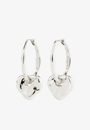 Strieborné kruhové náušnice s hladkým, zaobleným príveskom v tvare srdca visiaci z každého kruhu na bielom pozadí.