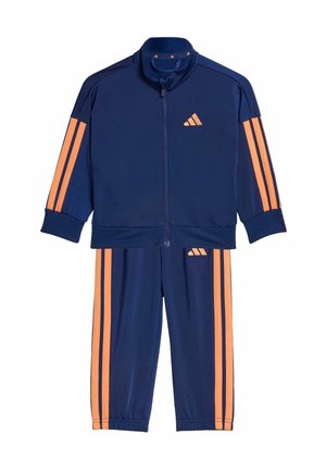 Chándal azul marino hecho de tela ligera, con rayas naranjas en las mangas y los pantalones, una chaqueta con cremallera y un logo bordado.