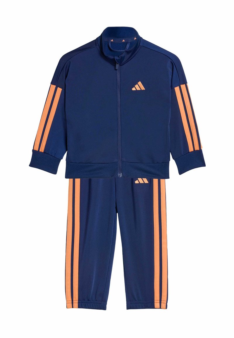 Tmavomodrá tepláková súprava z ľahkej látky, s oranžovými pruhmi na rukávoch a nohaviciach, so zapínaním na zips a vyšitým logom.